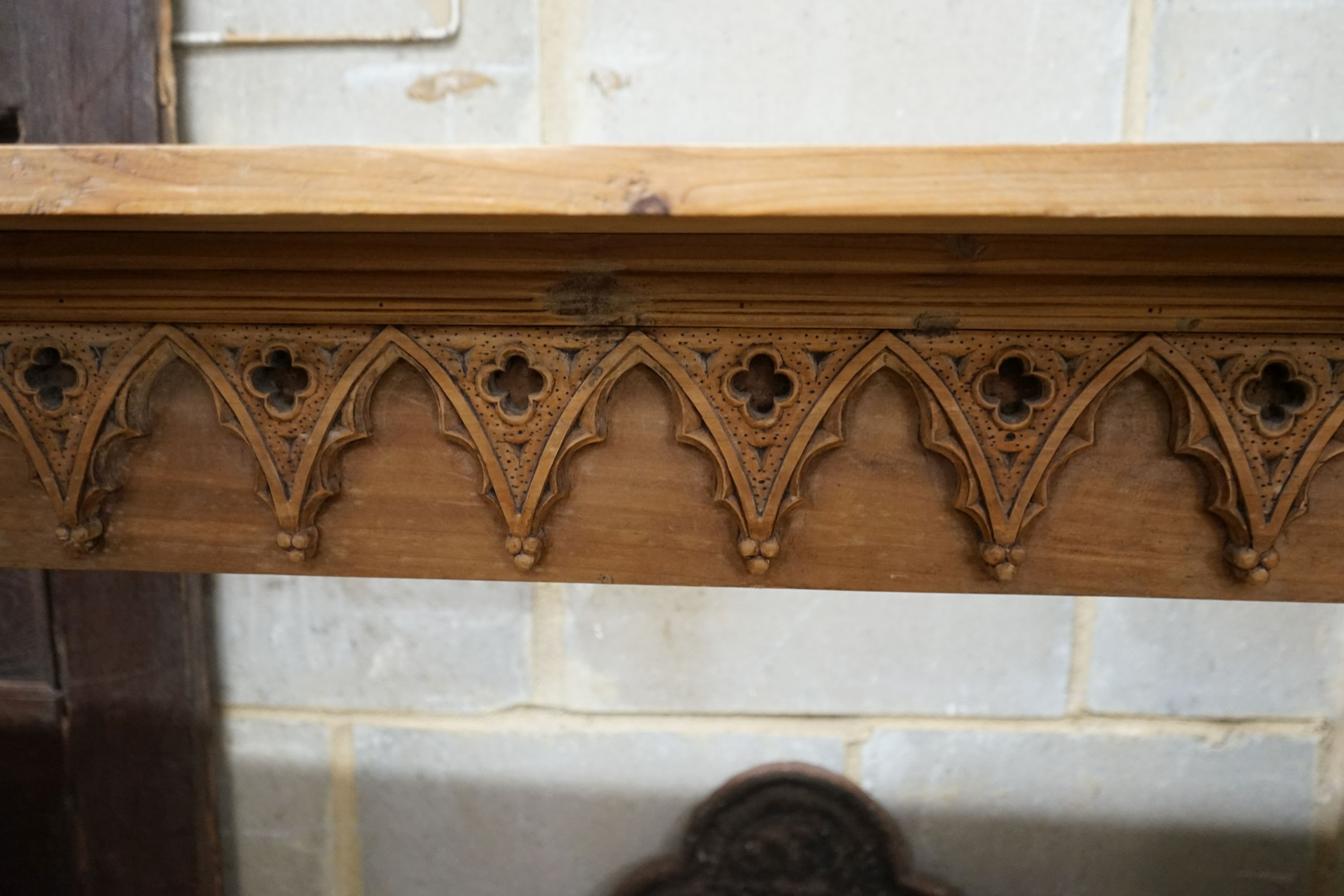 A George III style limewood chimneypiece, in the Strawberry Hill Gothic style, width 150cm, height 111cm together with a cast iron fireback and fire basket (3)